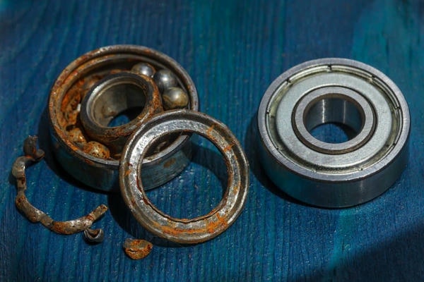 image shows a bad ball bearing and a normal ball bearing 
