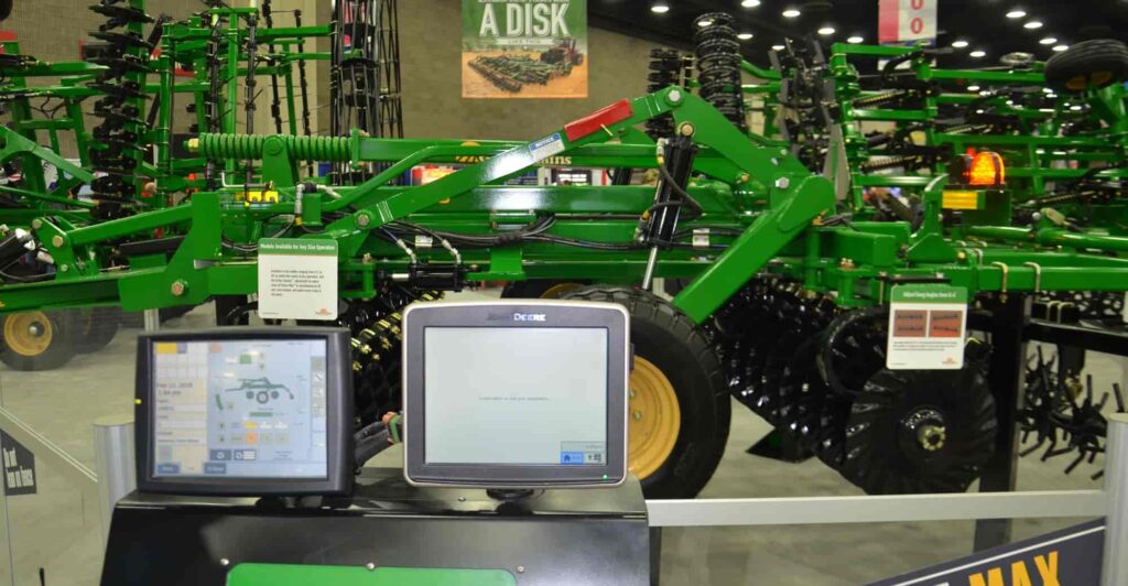  Jason inspecting a new tillage machine integrated with TFL bearings in a factory workshop, with performance data displayed nearby