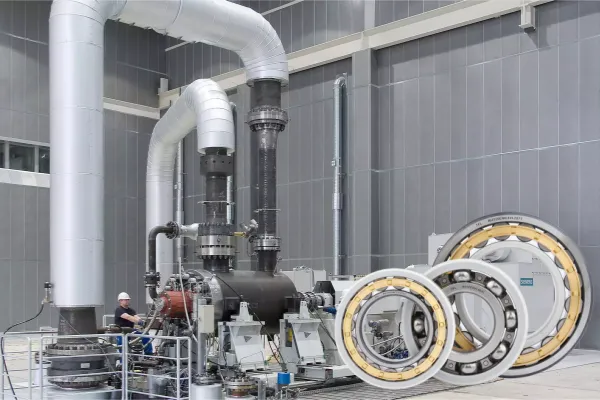 An image of a large pump in a power plant environment, with text overlays indicating how insulated bearings prevent pitting and fluting caused by electrical currents.