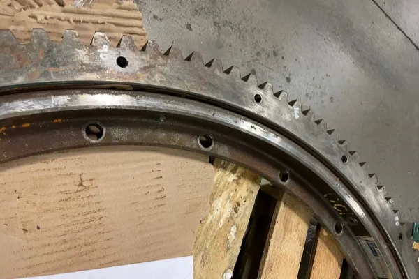 An image of a slewing bearing showing rust and small pits on the metal surface from corrosion.
