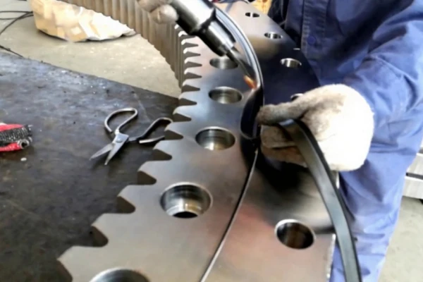 A technician is shown replacing a cracked or worn seal on a slewing bearing to prevent further damage.