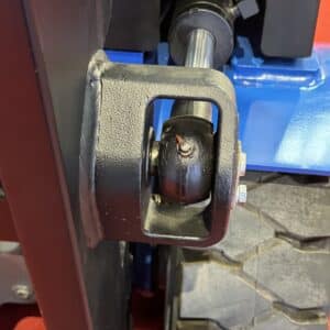 Forklift mast side guide roller assembly mounted on the carriage